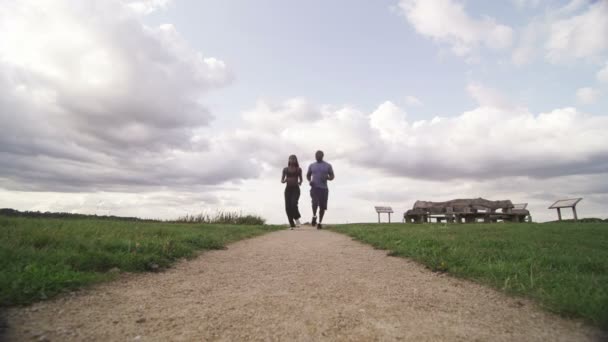 Man en vrouw rennen in het park — Stockvideo