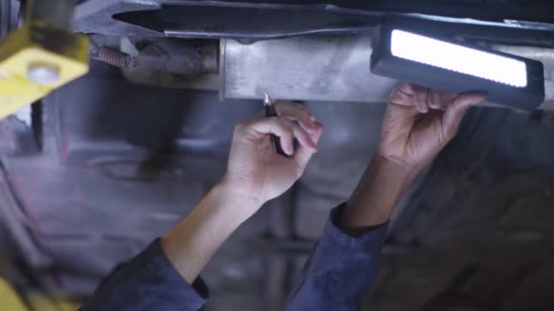 Mecánicos trabajando debajo de un coche — Vídeos de Stock