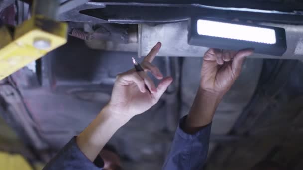 Mecánicos trabajando debajo de un coche — Vídeos de Stock