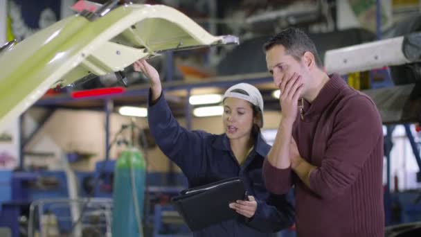 Mechanic in garage talking to customer — Stock Video