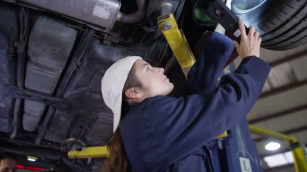 Mecânica trabalhando debaixo de um carro — Vídeo de Stock