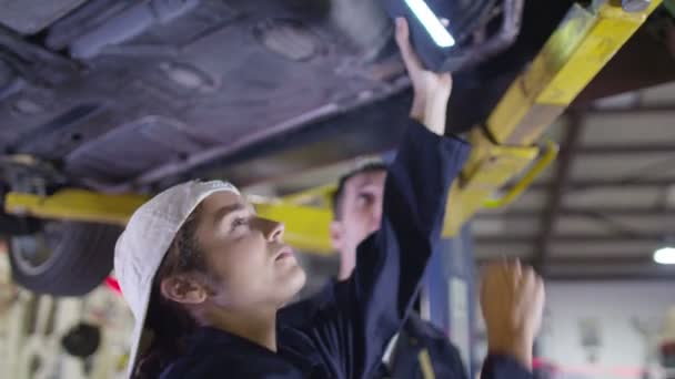 Mecánicos trabajando debajo de un coche — Vídeos de Stock