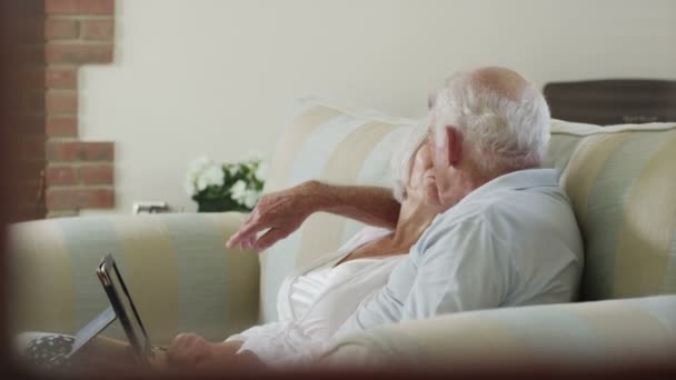 Pareja de ancianos con una tableta de ordenador — Vídeo de stock