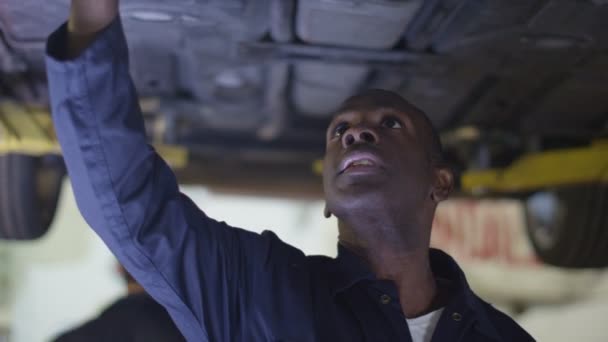 mécanicien travaillant sous une voiture  