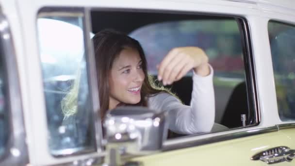 Женщина, сидящая в классической машине — стоковое видео