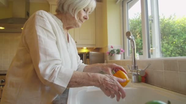 Senhora lavar legumes na cozinha — Vídeo de Stock