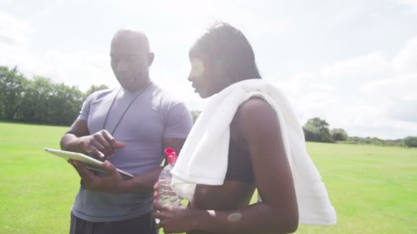 Vrouw met trainer kijken naar Tablet PC — Stockvideo