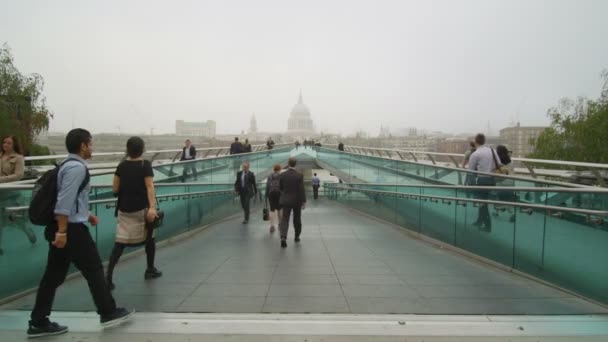 Menschen überqueren die Millennium-Fußgängerbrücke — Stockvideo