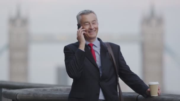 Uomo d'affari su un telefono cellulare in città — Video Stock