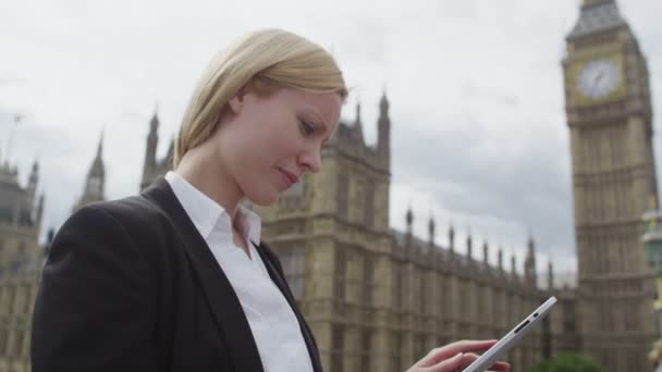 Женщина смотрит на планшетный компьютер — стоковое видео