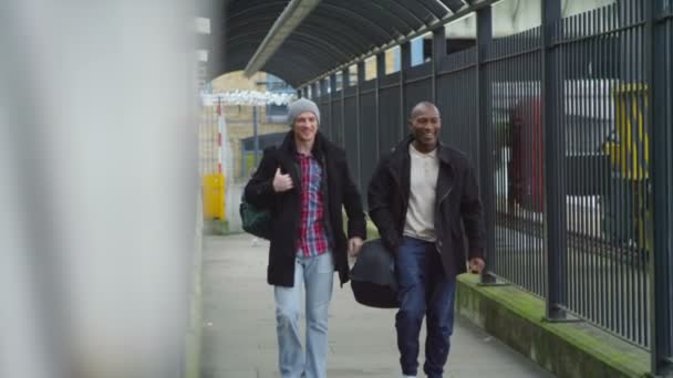 Vänner chattar som promenad från järnvägsstationen — Stockvideo
