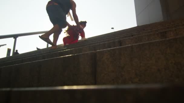 Madre e hijo subiendo un conjunto de escalones en la ciudad — Vídeo de stock