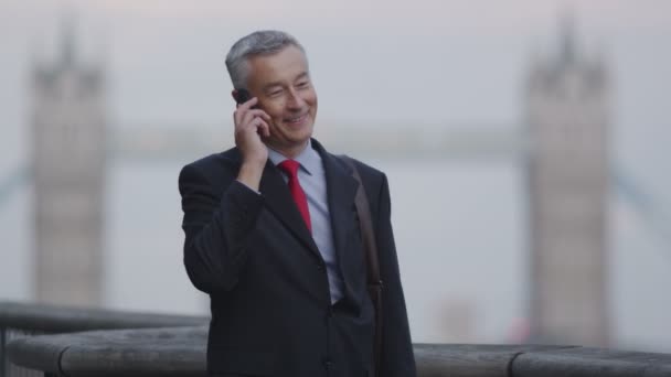 Zakenman op een mobiele telefoon in de stad — Stockvideo