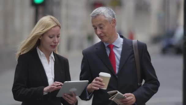 Geschäftsleute schauen auf ein Tablet — Stockvideo