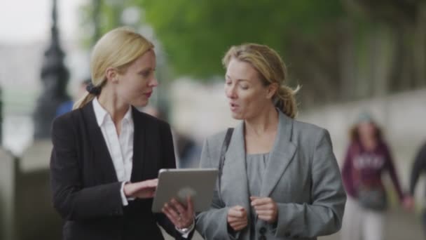 Geschäftsfrauen schauen sich Daten auf Tablet an — Stockvideo