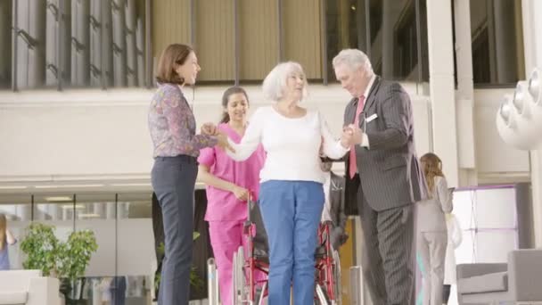 Medizinisches Personal hilft einem Patienten im Rollstuhl beim Stehen — Stockvideo