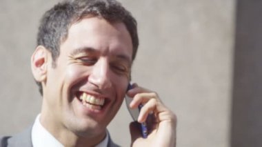 cep telefonuyla meslektaşı ile işadamı gülüyor 