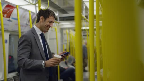 Бизнесмен в поезде смотрит на смартфон — стоковое видео