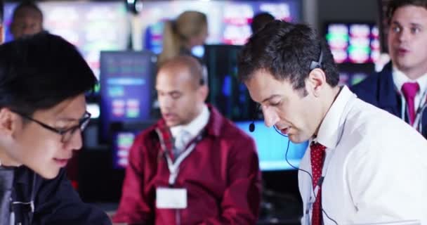 Corretores assistindo os mercados mundiais na sala de negociação — Vídeo de Stock