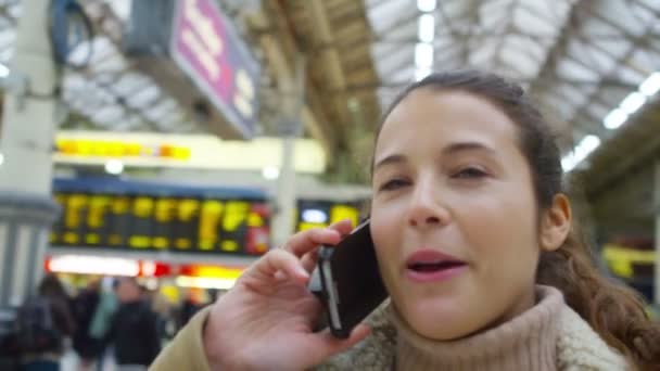 Vrouw op smartphone in station — Stockvideo