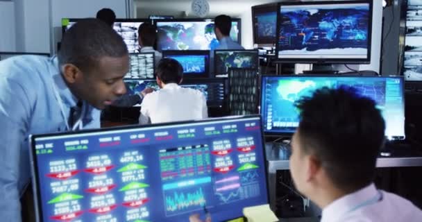 Corredores que observan los mercados mundiales en la sala de negociación — Vídeos de Stock