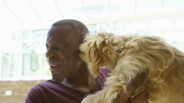 Hombre relajándose con el cachorro lamiendo su cara — Vídeos de Stock