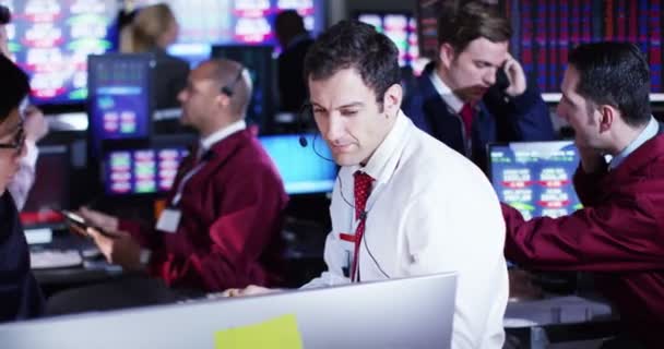 Corretores assistindo os mercados mundiais na sala de negociação — Vídeo de Stock