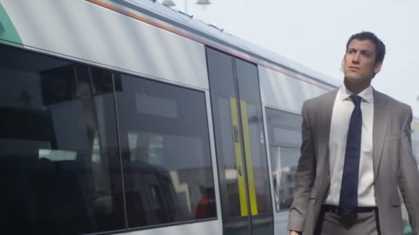 Hombre de negocios caminando por la estación de tren — Vídeo de stock