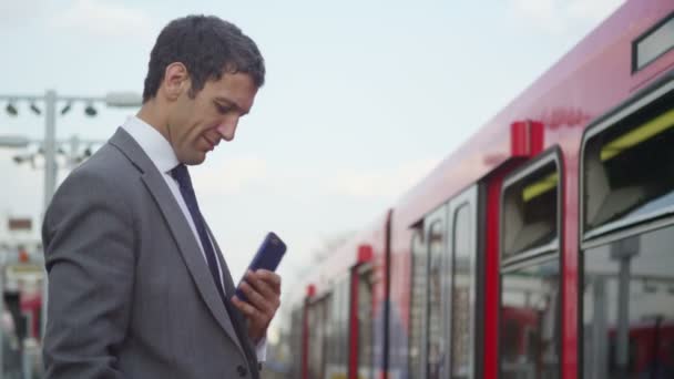 Business man texting on his smartphone — стоковое видео