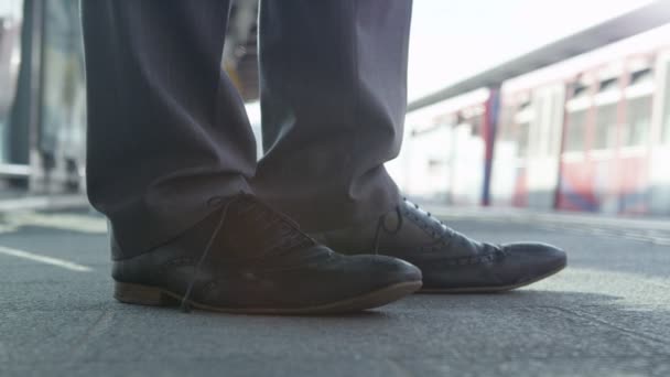 鉄道駅のプラットフォームに立っている足 — ストック動画