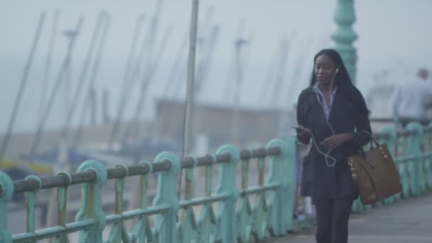 Vrouw met koptelefoon praten op mobiele telefoon — Stockvideo