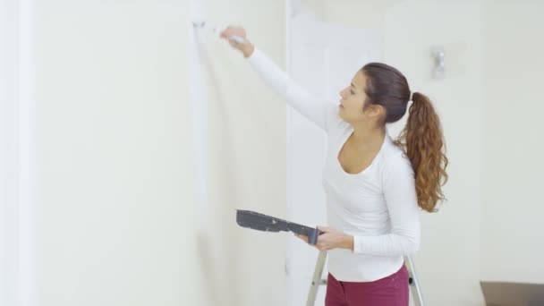 Mulher pintando uma parede em nova casa — Vídeo de Stock