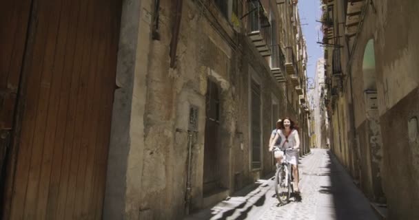 Пара езда на велосипеде в итальянском городе — стоковое видео