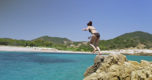 Woman jumping into the clear blue water — Stock Video