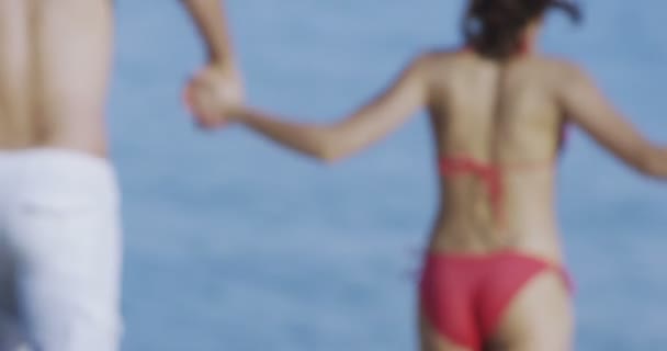 Pareja chapoteando en la playa — Vídeo de stock