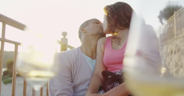 Paar zitten naast de zee bij zonsondergang — Stockvideo