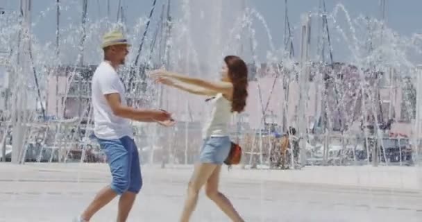 Couple cooling off near a water fountain — Stock Video