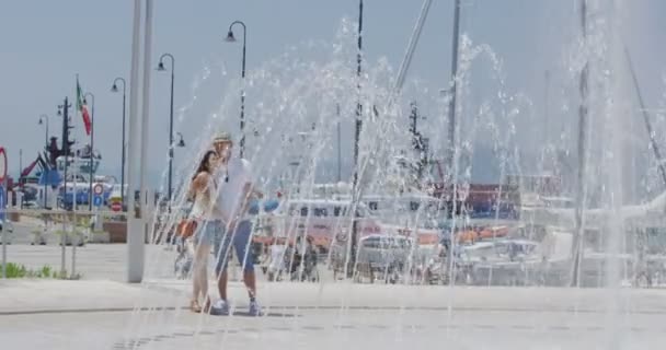 Пара охолоджується біля водного фонтану — стокове відео
