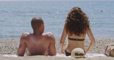 Kumsalda güneşlenirken Çift