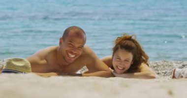 Kumsalda güneşlenirken Çift