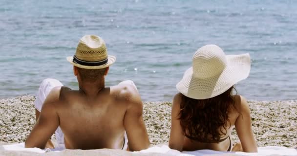 Casal de banhos de sol na praia — Vídeo de Stock