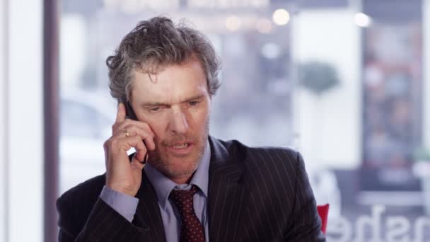 Бизнесмен вешает трубку во время телефонного разговора — стоковое видео