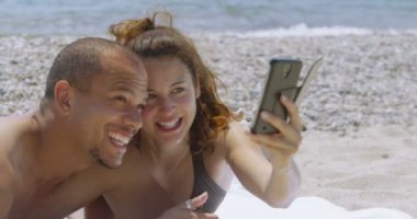 Çift bir cep telefonu ile sahilde rahatlatıcı