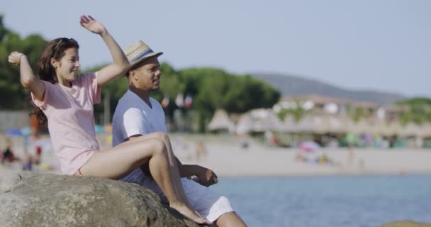Paar wirft Steine auf den Strand — Stockvideo