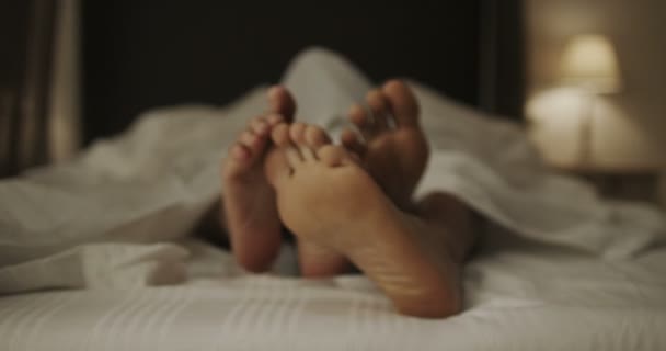 Happy feet of couple in bed — Stock Video