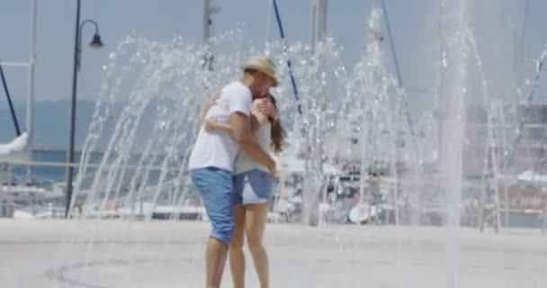 Couple cooling off near a water fountain — Stock Video
