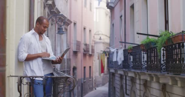 Mann mit Laptop auf Balkon — Stockvideo