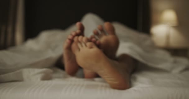 Happy feet of couple in bed — Stock Video