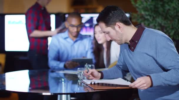 Businessman sitting with colleagues in office — Wideo stockowe