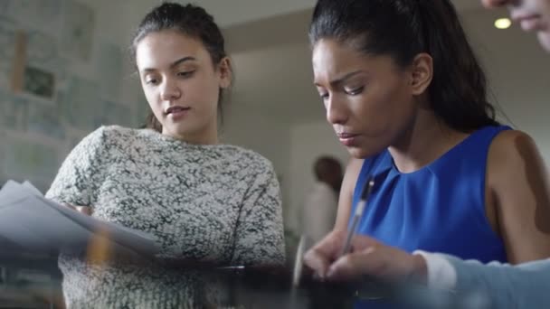 Zakenvrouwen kijkt uit over de cijfers in een vergadering — Stockvideo